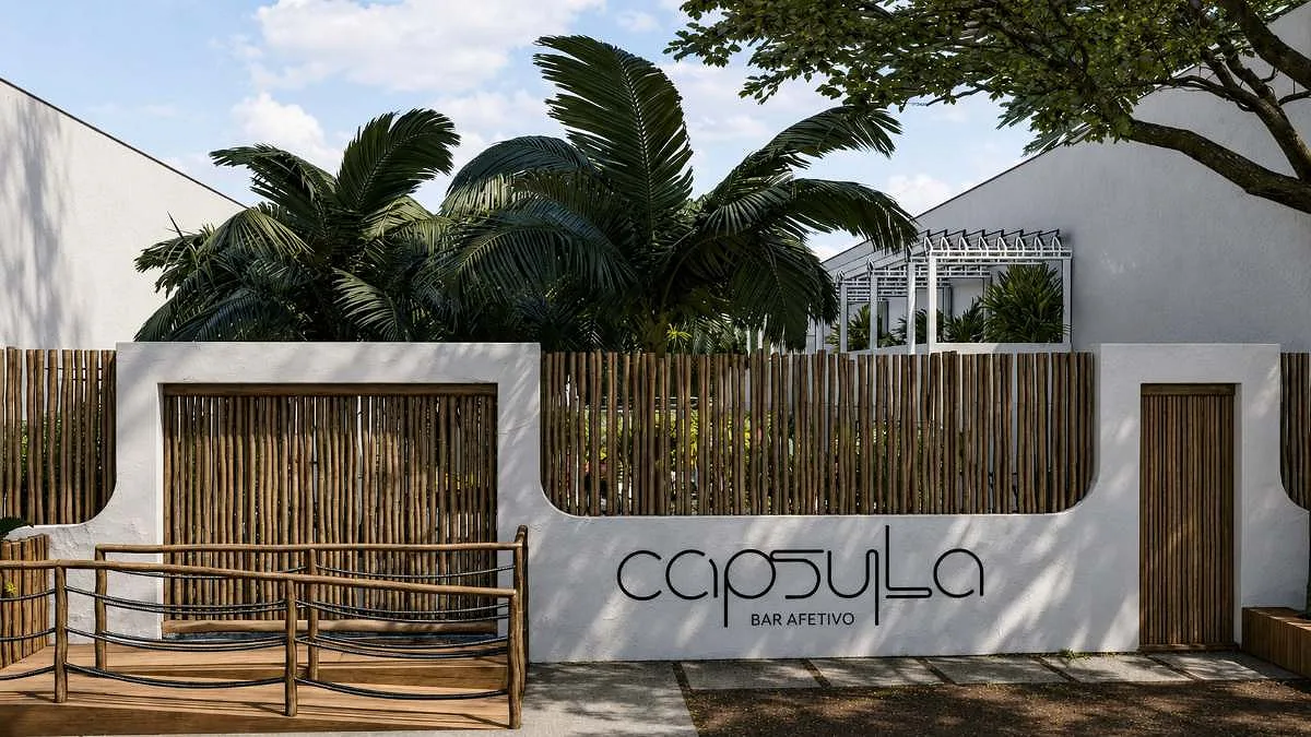 Fachada do Cápsula Bar em taipa e madeira, iluminada à noite